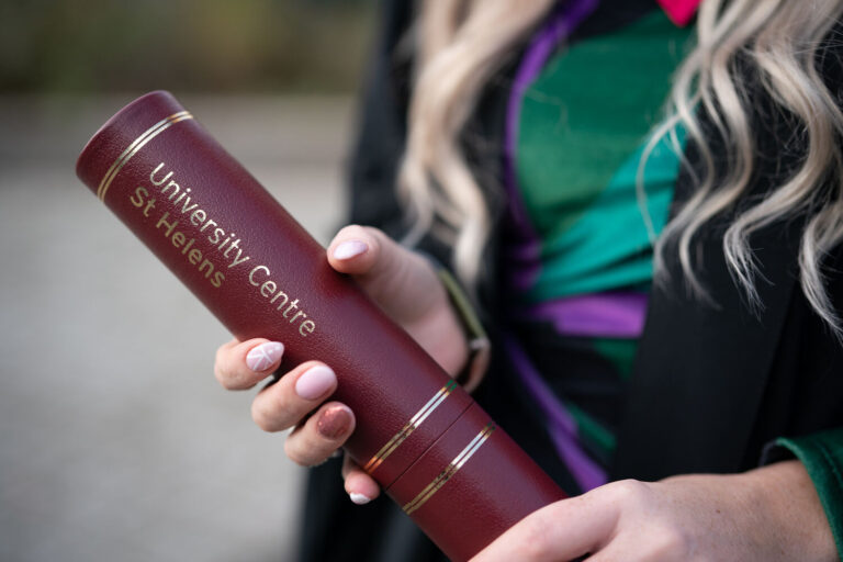 student with their degree scroll